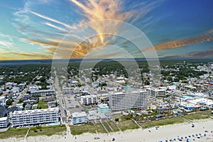 aerial shot of the coastline with the Carolina Beach Boardwalk, homes, hotels and restaurants with people relaxing in the sand