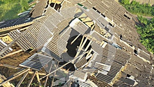 Aerial shot of the destroyed roof of an abandoned cattle barn.