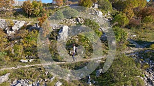 Aerial shot. Drone follows the man as he walks down the hill away from the Fortress Kosmach in Montenegro. An old