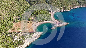 Aerial shot from drone of Mylokopi bay and beaches, Greece, with beautiful glimmering and shining sea with tones of blue and turqu