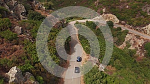 Aerial shot of electric car driving on a sunny road highway to mountains landscape.Luxury modern vehicle riding fast