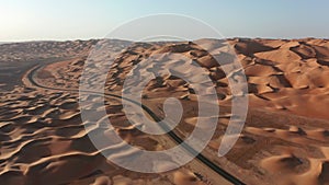 Aerial shot of empty road in desert dunes