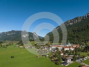 Aerial shot of Ettal Germany surrounded by green fields and scenic mountains photo