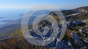 Aerial shot. Family of toursts father mother and son visit the Fortress Kosmach in Montenegro. Drone rotates around them