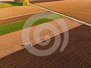 Aerial shot of a farmer plowing stubble field