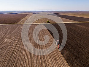 Aerial shot of a farmer plowing stubble field