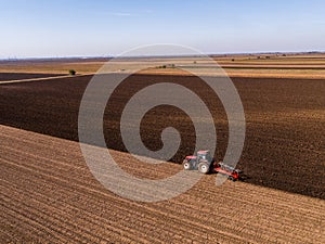 Aerial shot of a farmer plowing stubble field