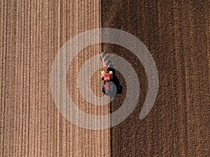 Aerial shot of a farmer plowing stubble field