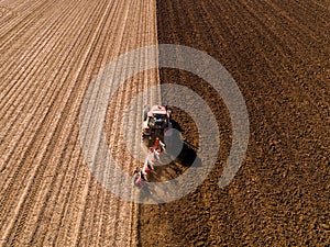 Aerial shot of a farmer plowing stubble field