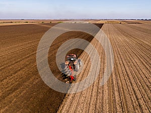 Aerial shot of a farmer plowing stubble field