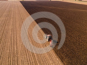 Aerial shot of a farmer plowing stubble field