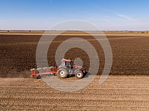 Aerial shot of a farmer plowing stubble field