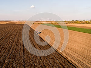 Aerial shot of a farmer plowing stubble field