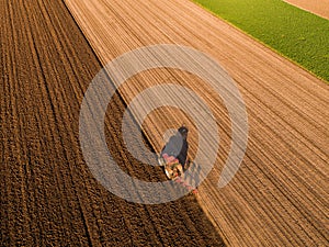 Aerial shot of a farmer plowing stubble field