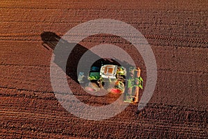 Aerial shot of Farmer with a tractor on the agricultural field