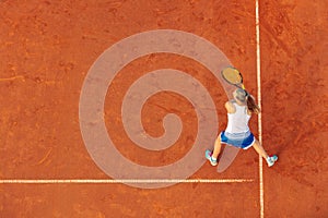 Aerial shot of a female tennis player on a court during match. Young woman playing tennis.High angle view.