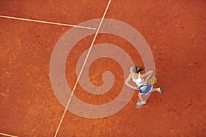 Aerial shot of a female tennis player on a court during match. Young woman playing tennis.High angle view.