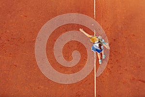 Aerial shot of a female tennis player on a court during match. Young woman playing tennis.High angle view.