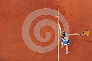 Aerial shot of a female tennis player on a court during match. Young woman playing tennis.High angle view.