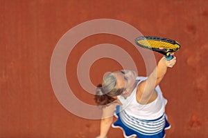 Aerial shot of a female tennis player on a court during match. Young woman playing tennis.High angle view.