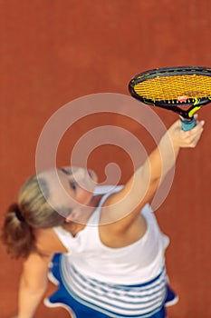 Aerial shot of a female tennis player on a court during match. Young woman playing tennis.High angle view.