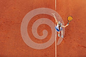 Aerial shot of a female tennis player on a court during match. Young woman playing tennis.High angle view.