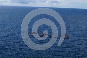 Aerial shot of the fishing nets and farm in the blue ocean with the horizon in the background