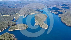 Aerial shot of forest islands scattered in turquoise waters and on the horizo