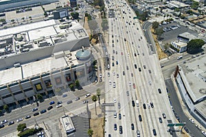 aerial shot freeway with cars and trucks driving with the Los Angeles Convention Center, office buildings, apartments