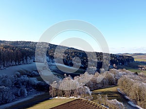 Aerial shot of frosted trees in the forest during the winter season