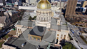 Aerial shot of the Georgia Capitol Museum surrounded by skyscrapers and office buildings with cars driving on the freeway