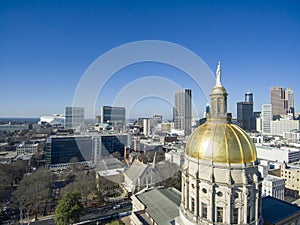 Aerial shot of the golden dome of Georgia Capitol Museum surrounded by office buildings and cars driving on the street photo