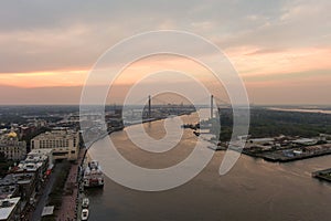 aerial shot of a gorgeous sunset over the Savannah River with Talmadge Memorial Bridge, hotels, restaurants and bars and shops