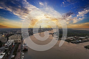 aerial shot of a gorgeous sunset over the Savannah River with Talmadge Memorial Bridge, hotels, restaurants and bars and shops