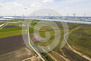 aerial shot of green fields, windmills and a river in the background, sunny day, Botlek, Netherlands