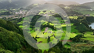 Aerial shot of green meadows, mountains and Furnas city on Sao Miguel Island, Azores, Portugal . Azores nature on sunny