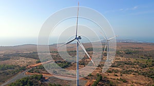 Aerial shot of a group of wind turbines in a semidesert environment. Green energy concept