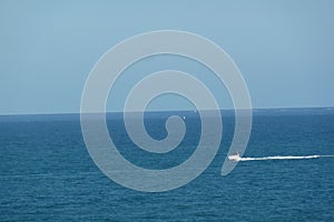 Aerial shot of high speed boat in blue sea under clear sky