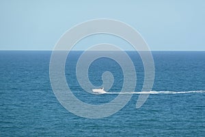 Aerial shot of high speed boat in blue sea under clear sky