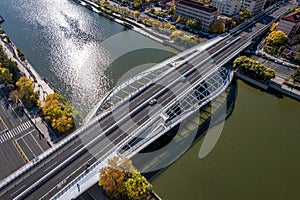 Aerial shot of a highway bridge over a river with shining water under the sunbeams