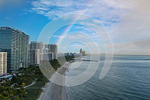 aerial shot of hotels, luxury condos and skyscrapers along the coastline at sunrise at Bal Harbour Beach, blue ocean water