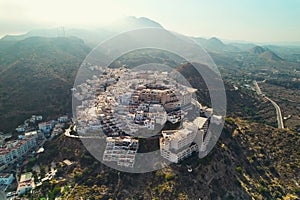 Aerial shot houses rooftops and mountains of Mojacar village. Spain