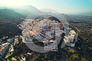 Aerial shot houses rooftops and mountains of Mojacar village. Spain