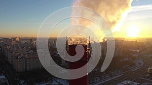 Aerial shot of an industrial smoke stack on street background in the evening. Urban air pollution