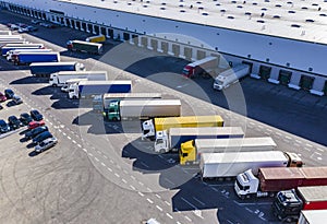 Aerial Shot of Industrial Warehouse Area where Many Trucks Are Loading Merchandise