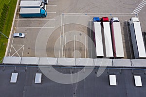 Aerial Shot of Industrial Warehouse Area where Many Trucks Are Loading Merchandise