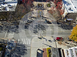 An aerial shot of an intersection with a gorgeous winter landscape with red and yellow trees, buildings and cars parked