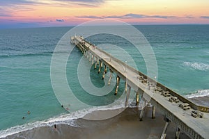aerial shot of Johnnie Mercer\'s Fishing Pier with vast blue ocean water and people walking along the pier