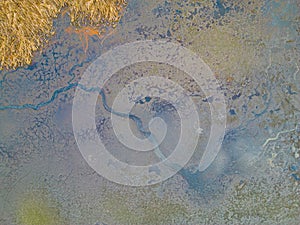 An aerial shot of the landscape with small lake surrounded by trees and field