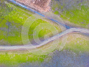 An aerial shot of the landscape with small lake surrounded by trees and field